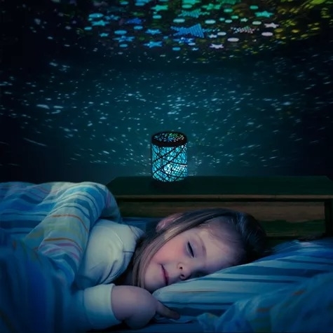 a child sleeps as a nightlight displays stars