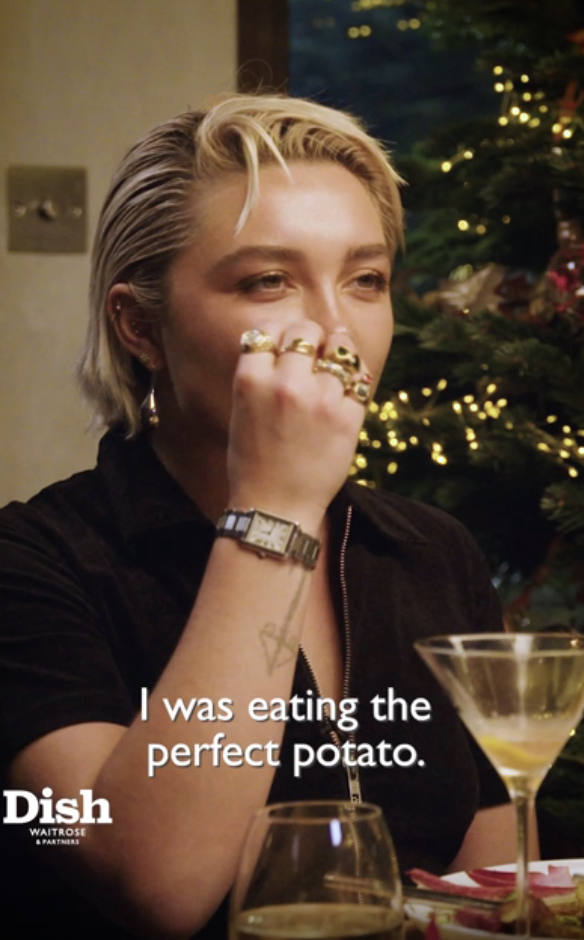 Close-up of Florence at a table on the show, with a Christmas tree behind her, and the caption, &quot;I was eating the perfect potato&quot;
