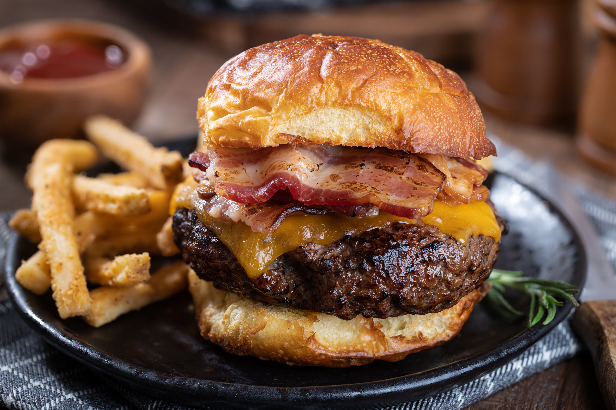 closeup of a bacon cheeseburger and fries