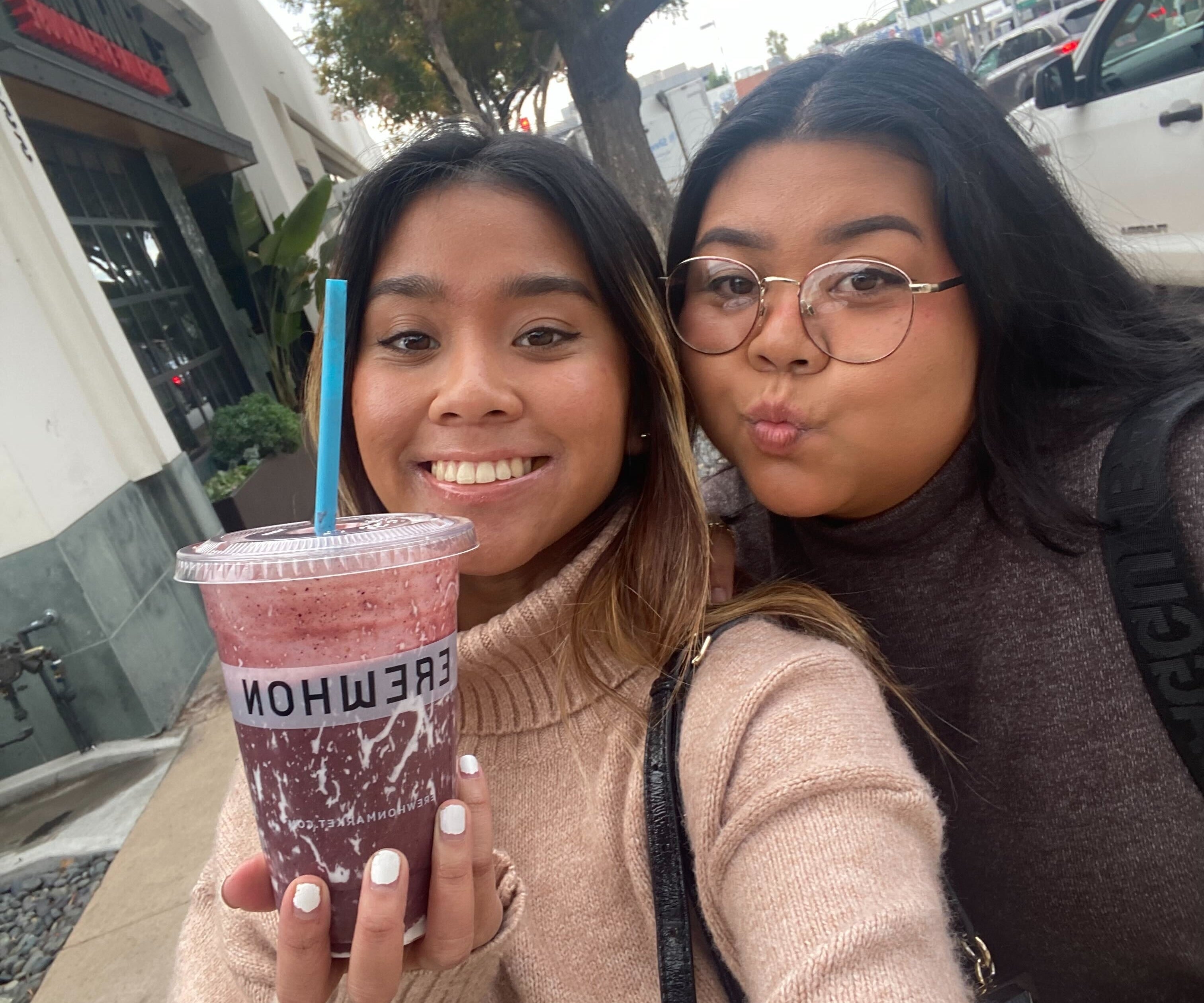 The author and her sister are posing with the Olivia Rodrigo smoothie