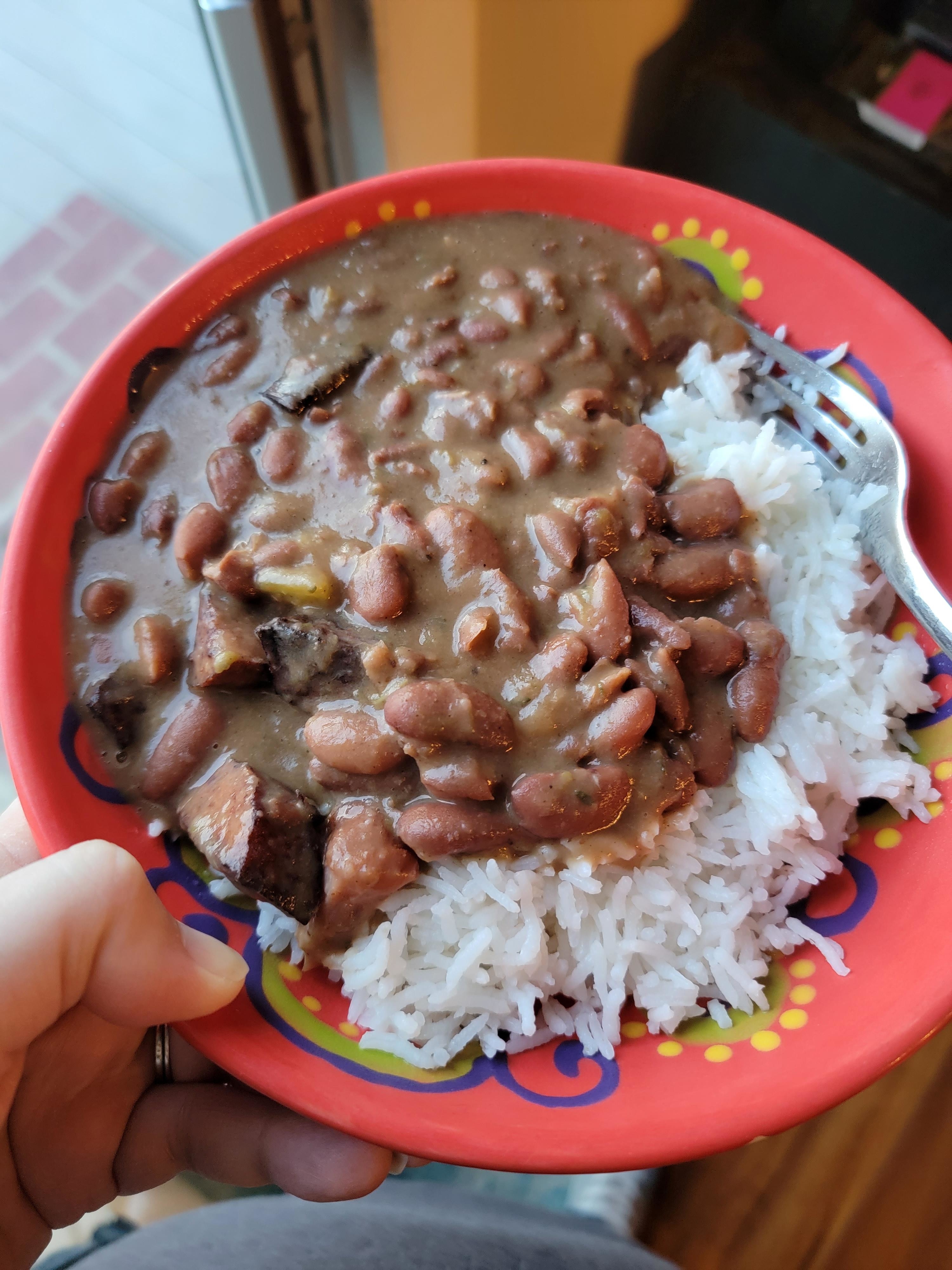 a bowl of red beans, sauce, and white rice