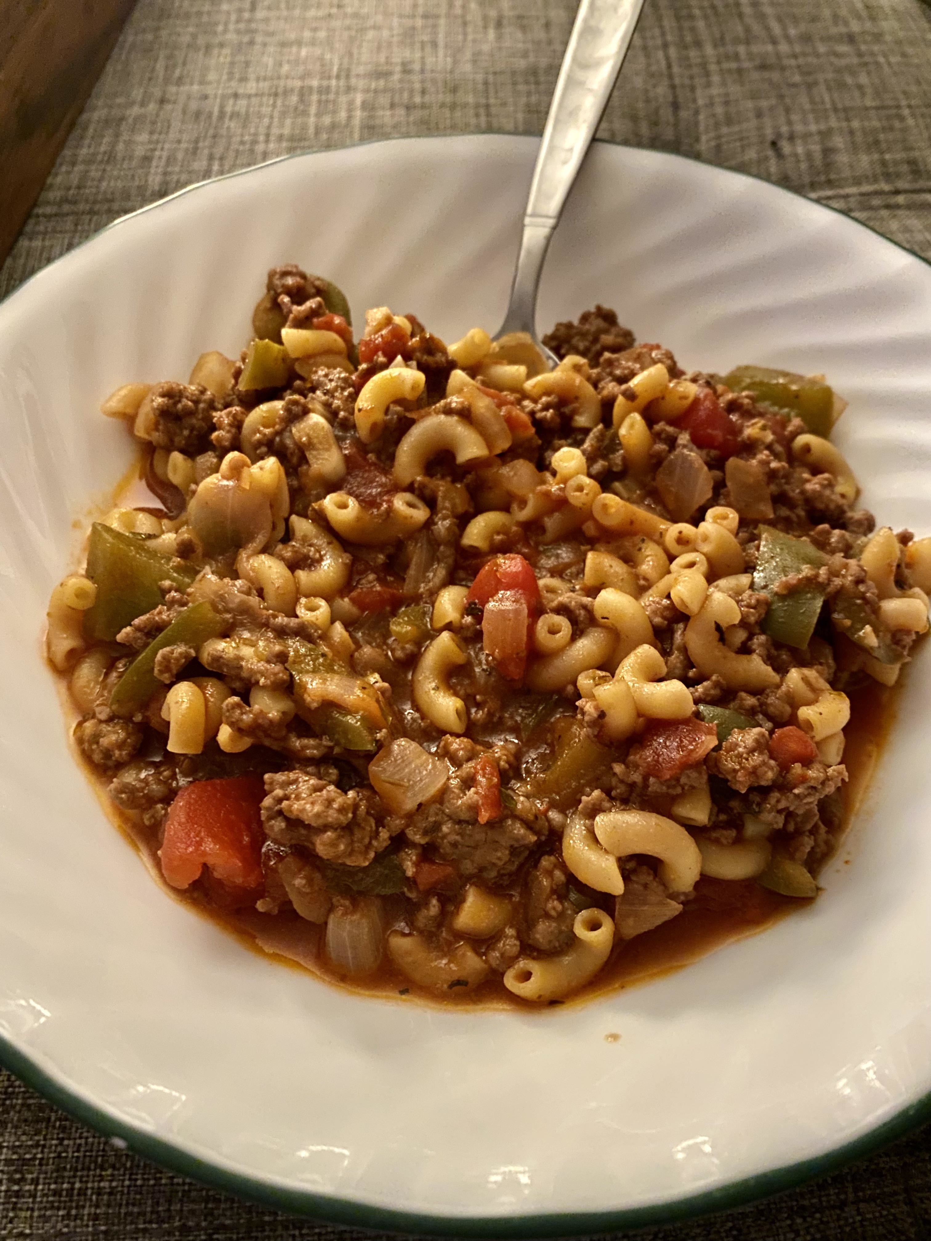 a plate of goulash with veggies and ground beef