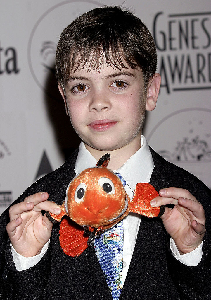him as a child wearing a suit and holding up a nemo toy