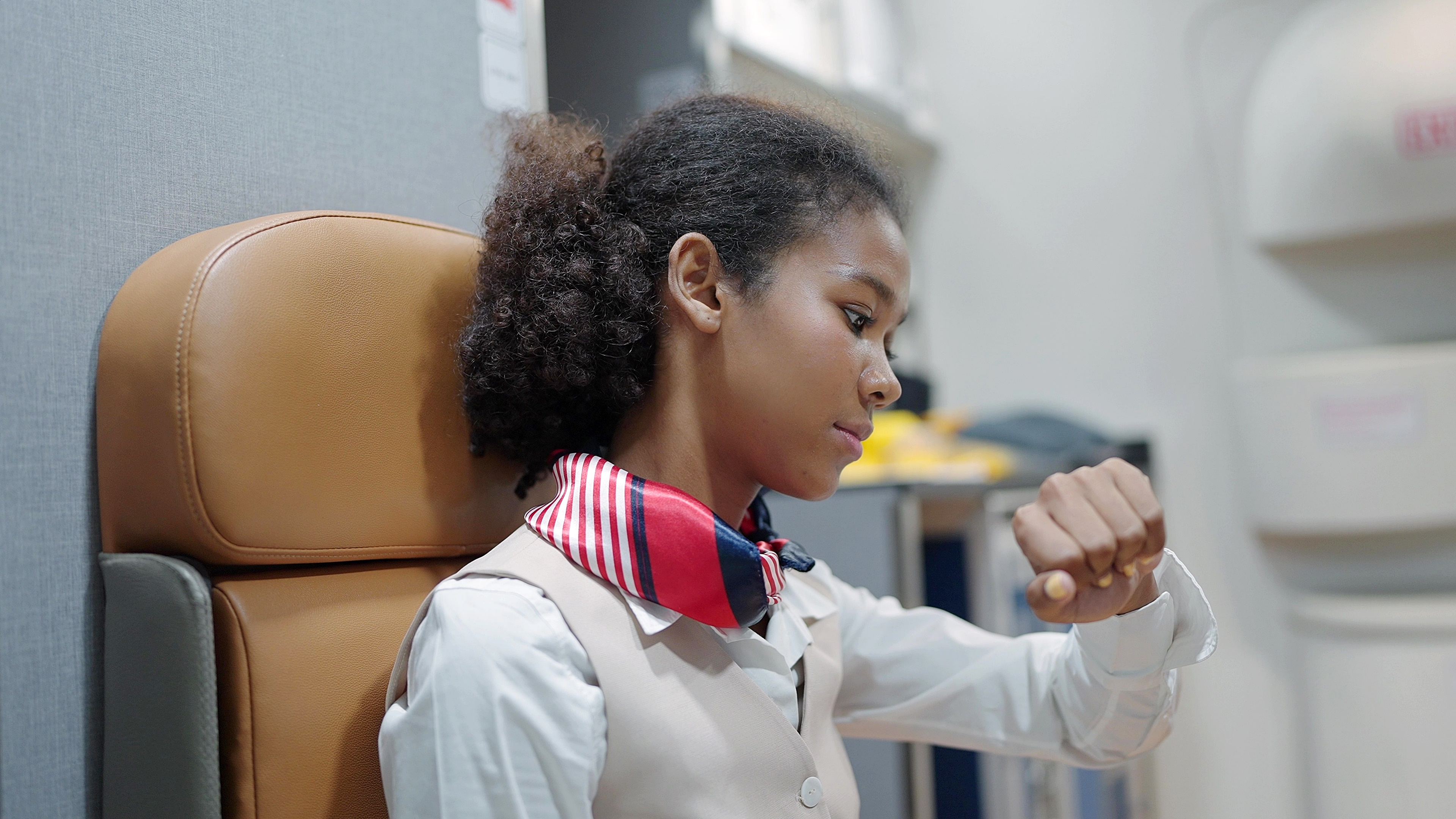 a young black flight attendant checking her watch