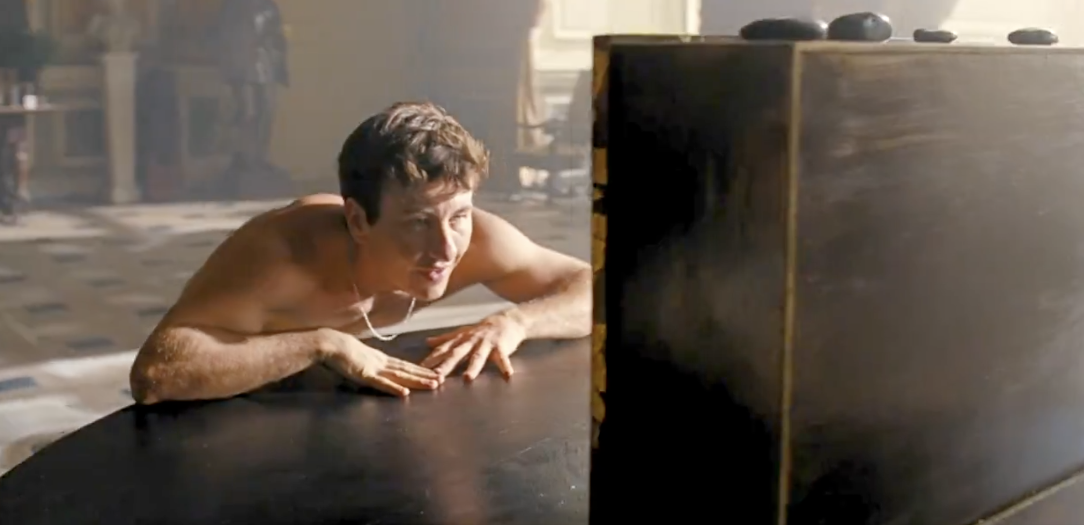 Barry seen naked from the waist up leaning on a table