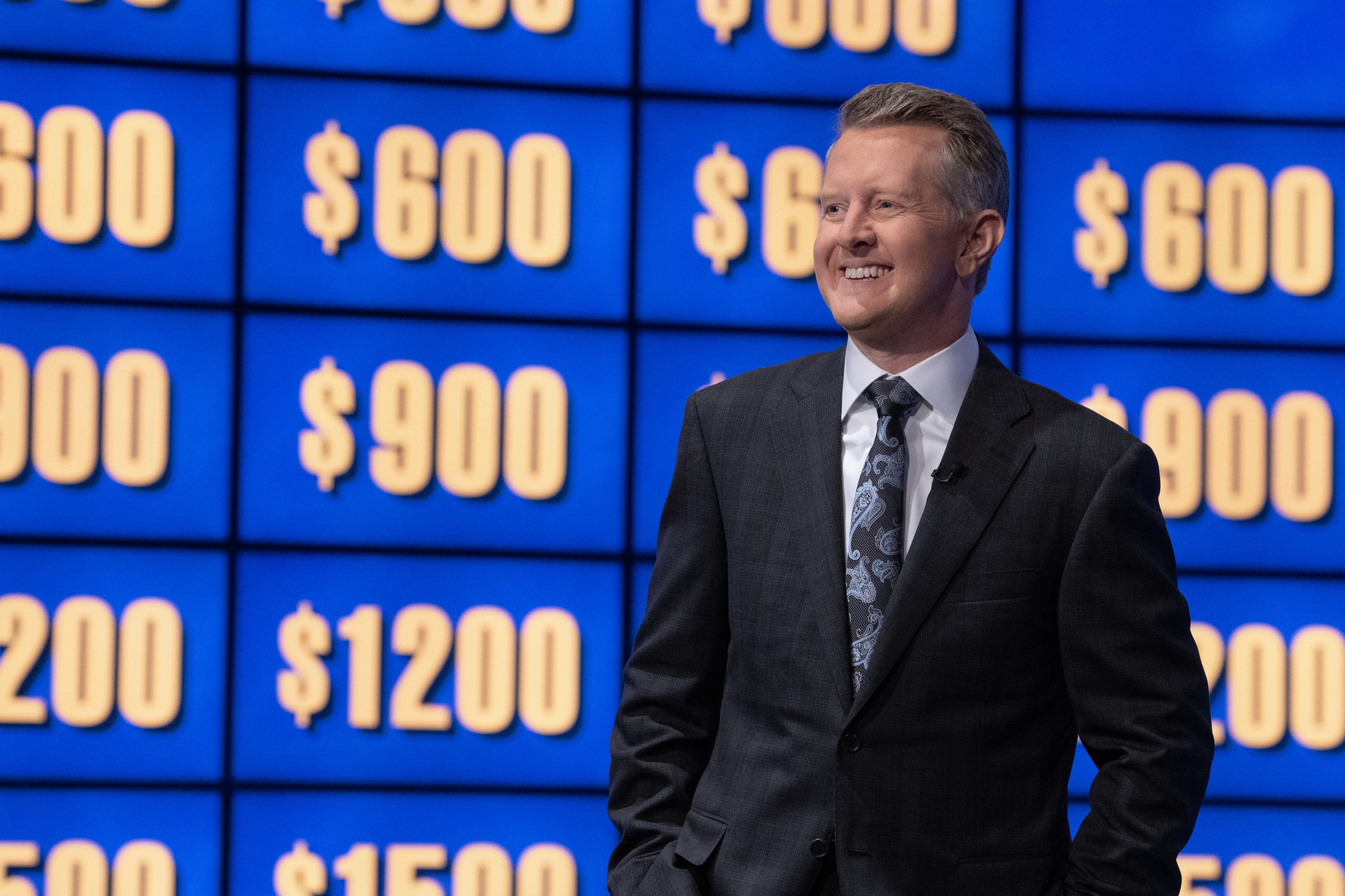 Ken in a suit and tie on Jeopardy smiling
