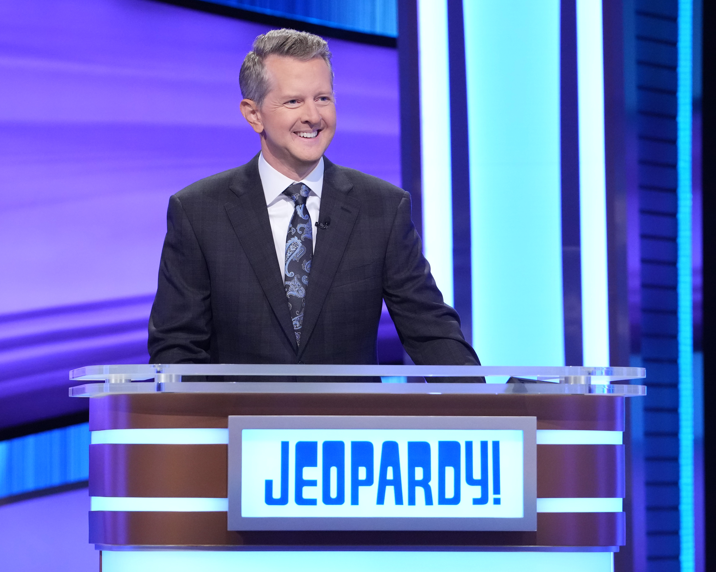 Ken smiling in a suit and tie on Jeopardy