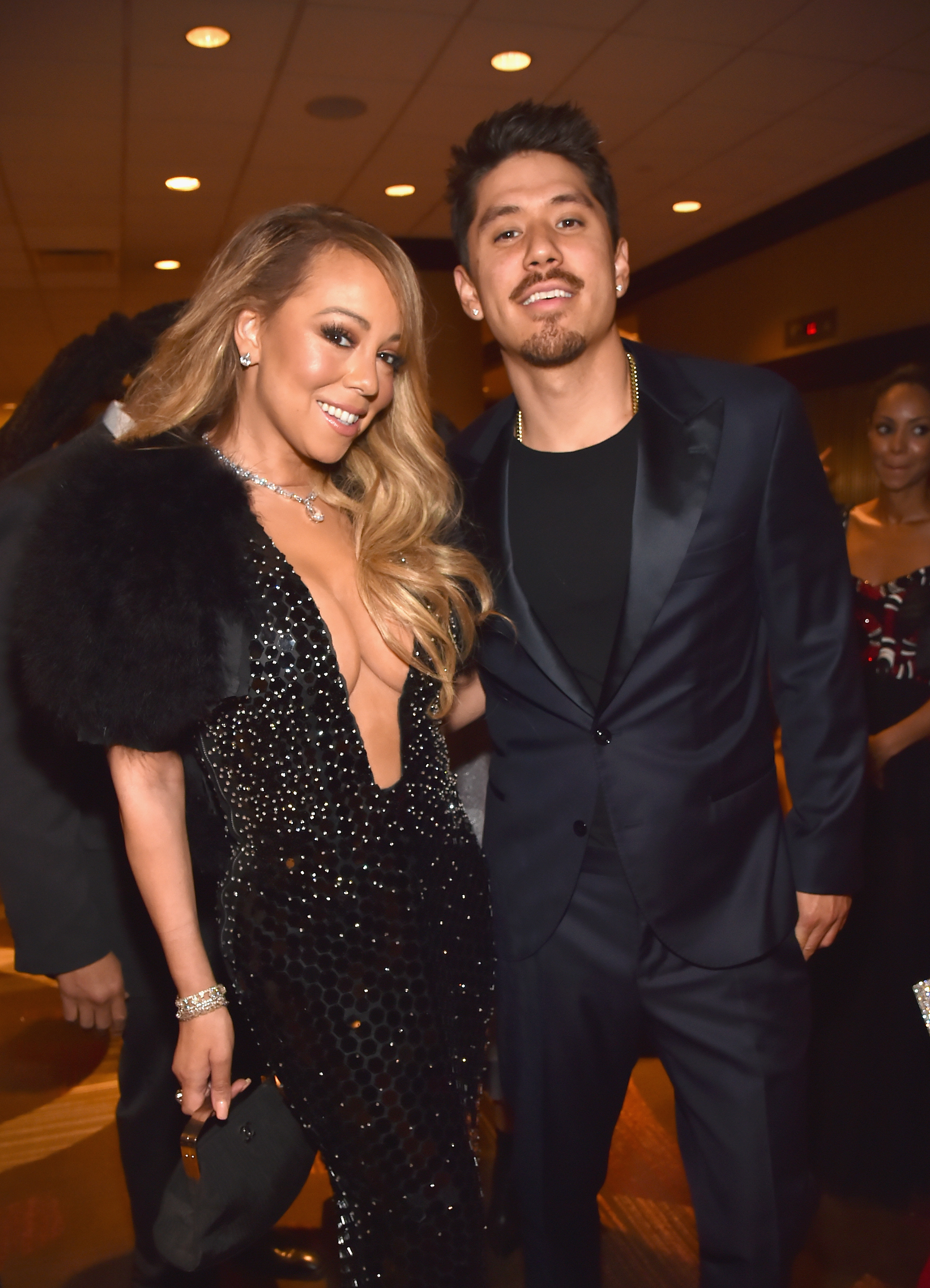 Mariah and Bryan smiling and standing together