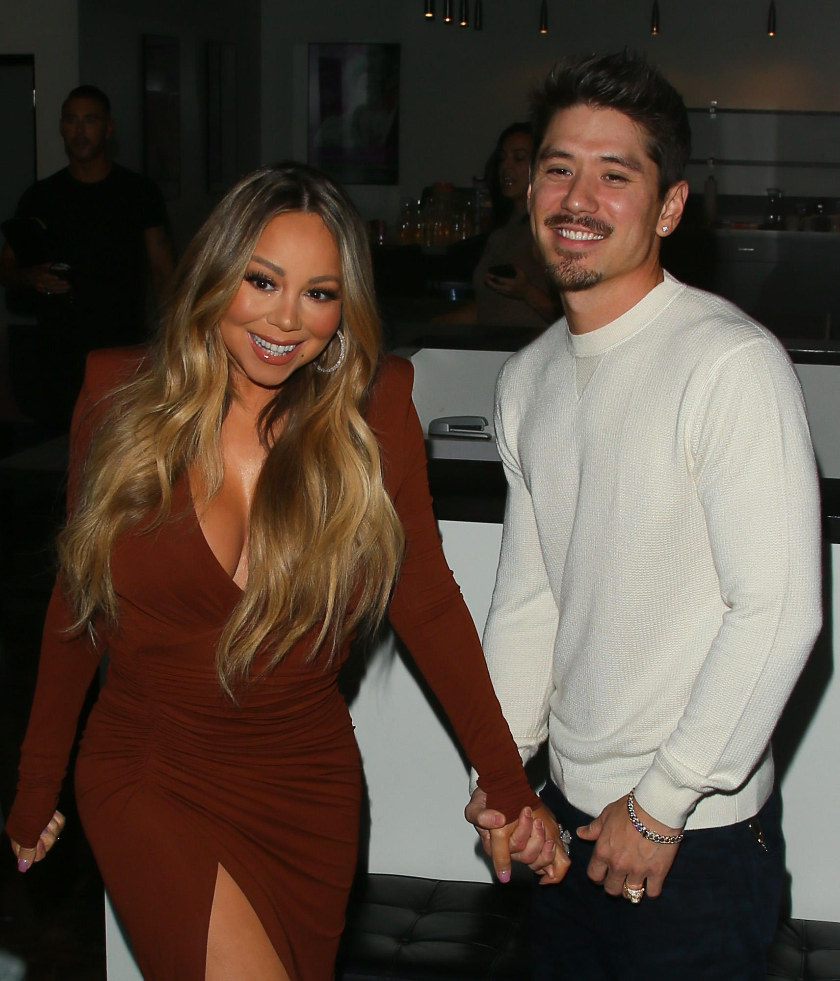 Mariah and Bryan smiling and holding hands