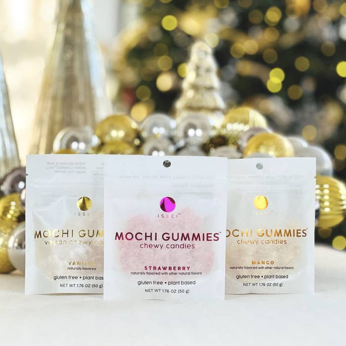 Three bags of Mochi Gummies in front of Christmas ornaments