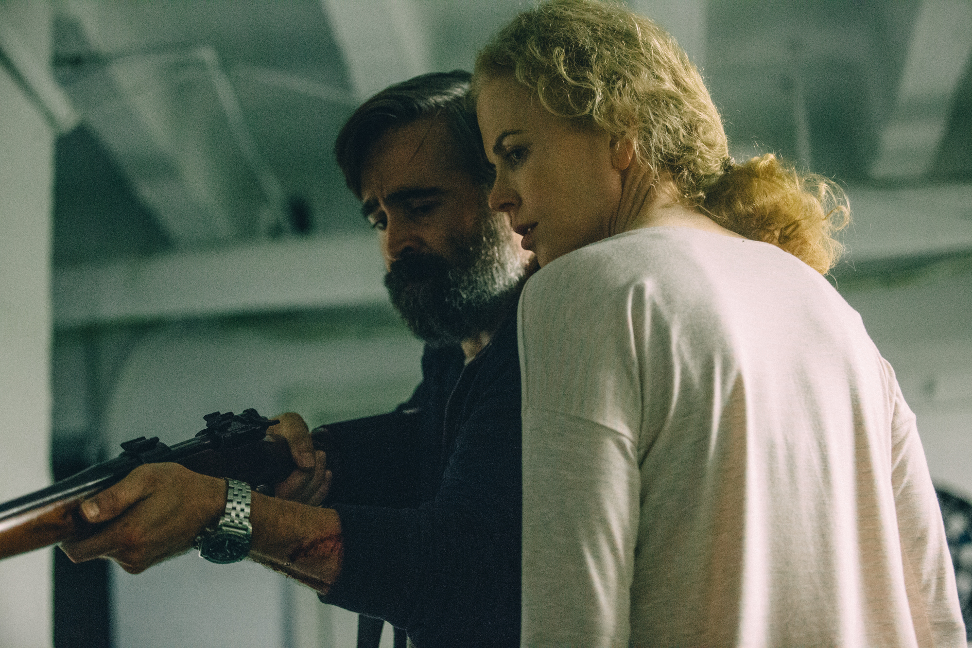 Nicole Kidman and Colin Farrell holding a rifle.