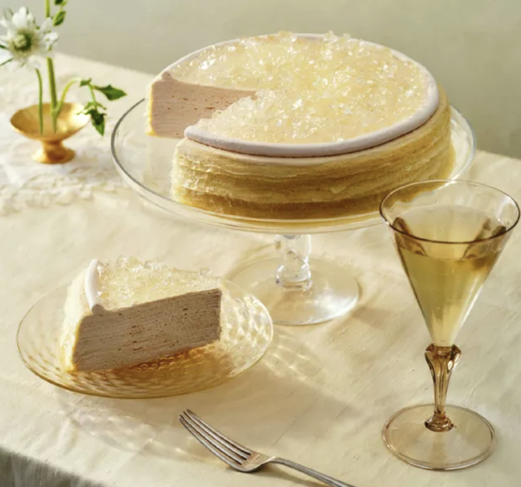 Champagne Mille Crepe next to slice and champagne glass