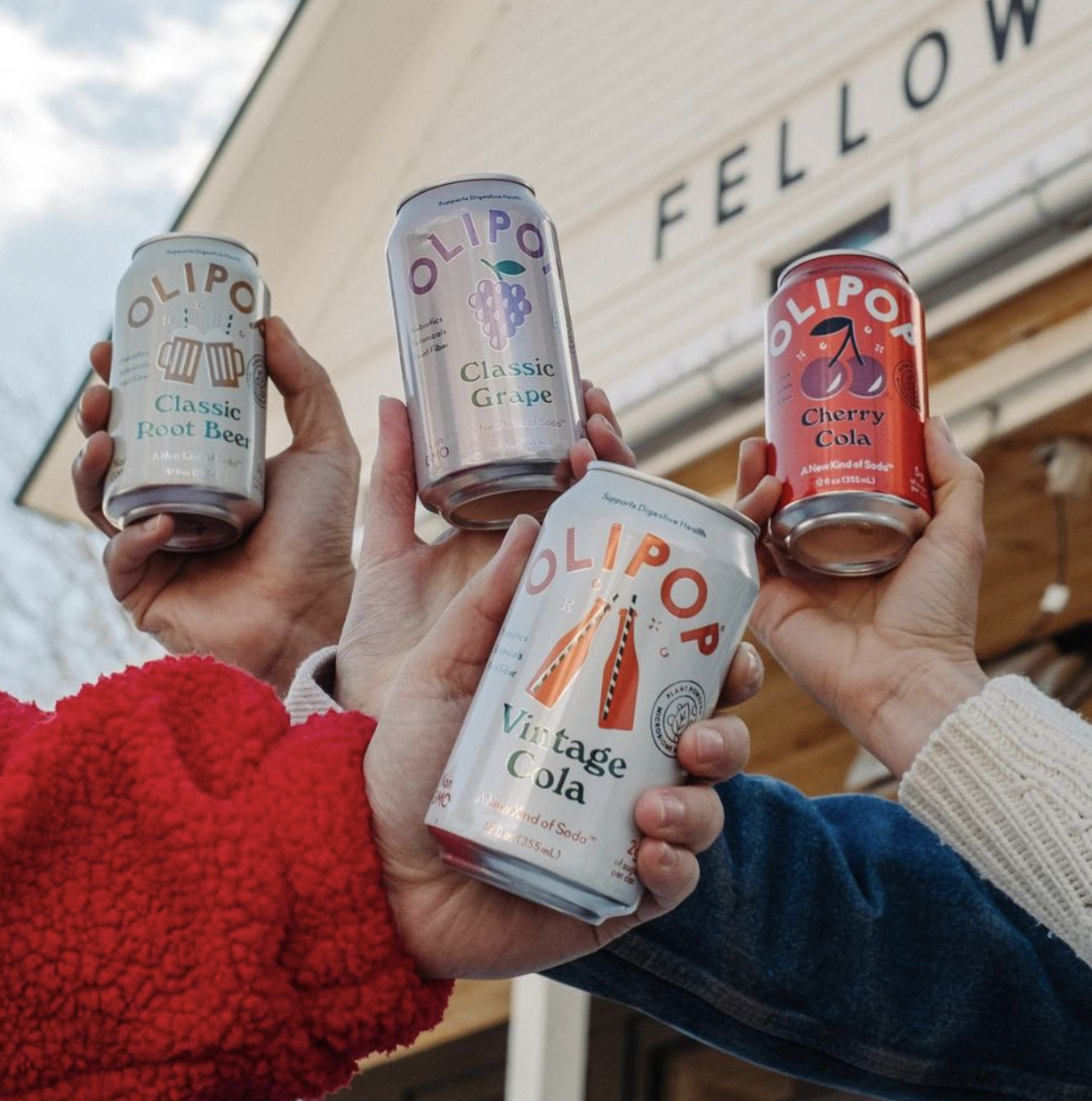 Four models holding cans of OLIPOP