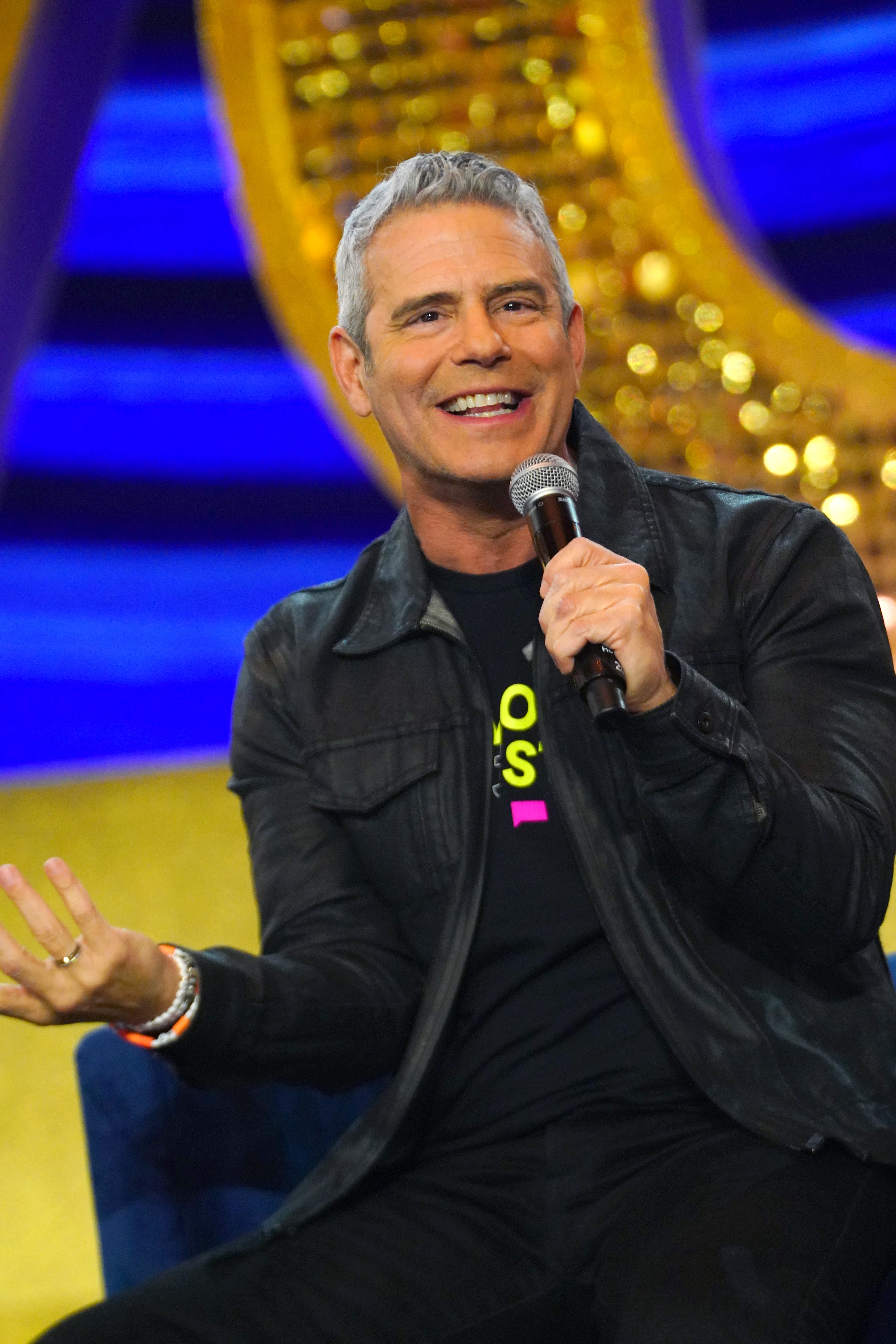 Andy seated and holding a microphone