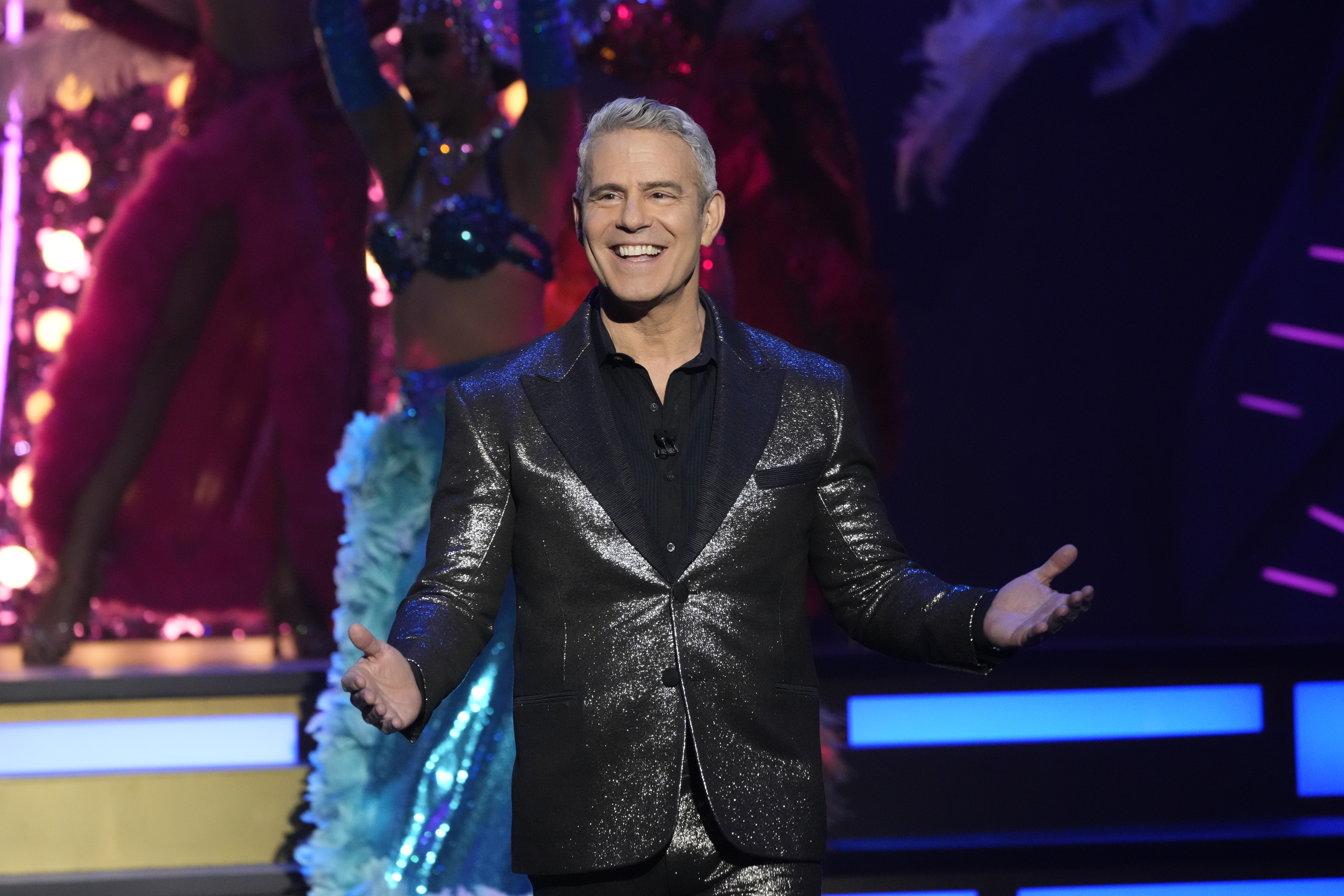 Close-up of Andy onstage and smiling in a shiny suit
