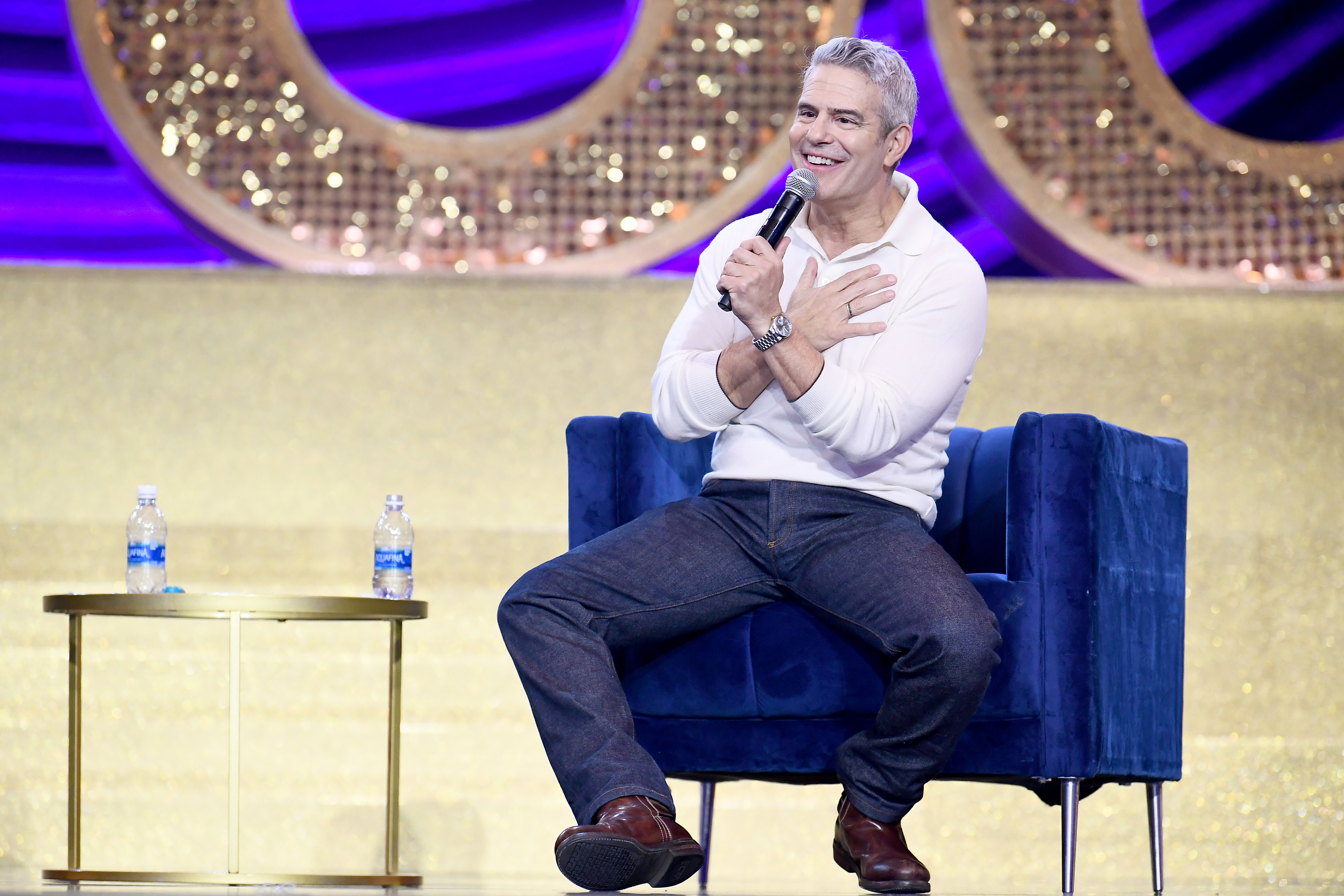 Close-up of Andy seated and holding a microphone