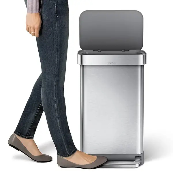 Woman stepping on stainless steel trash can