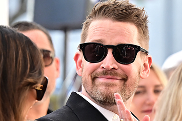 Macaulay Culkin waves to someone at his Hollywood Walk of Fame ceremony