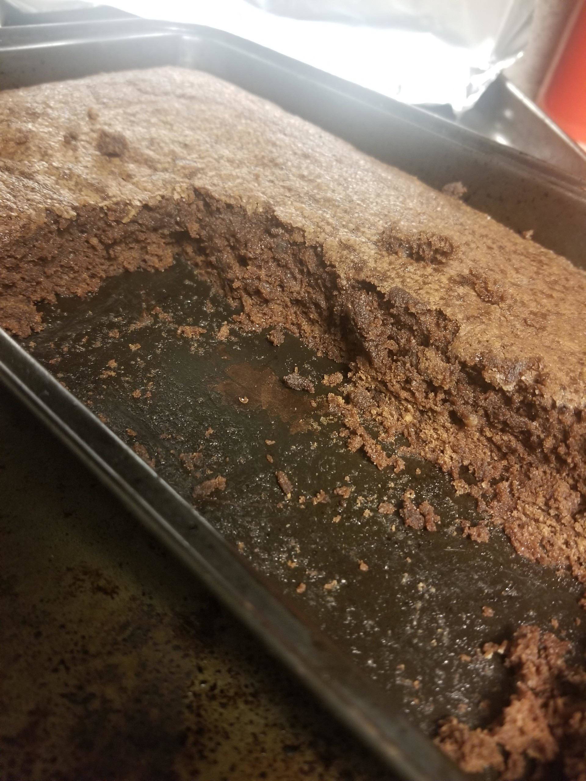 a tray of of baked brownies with a large slab cut out