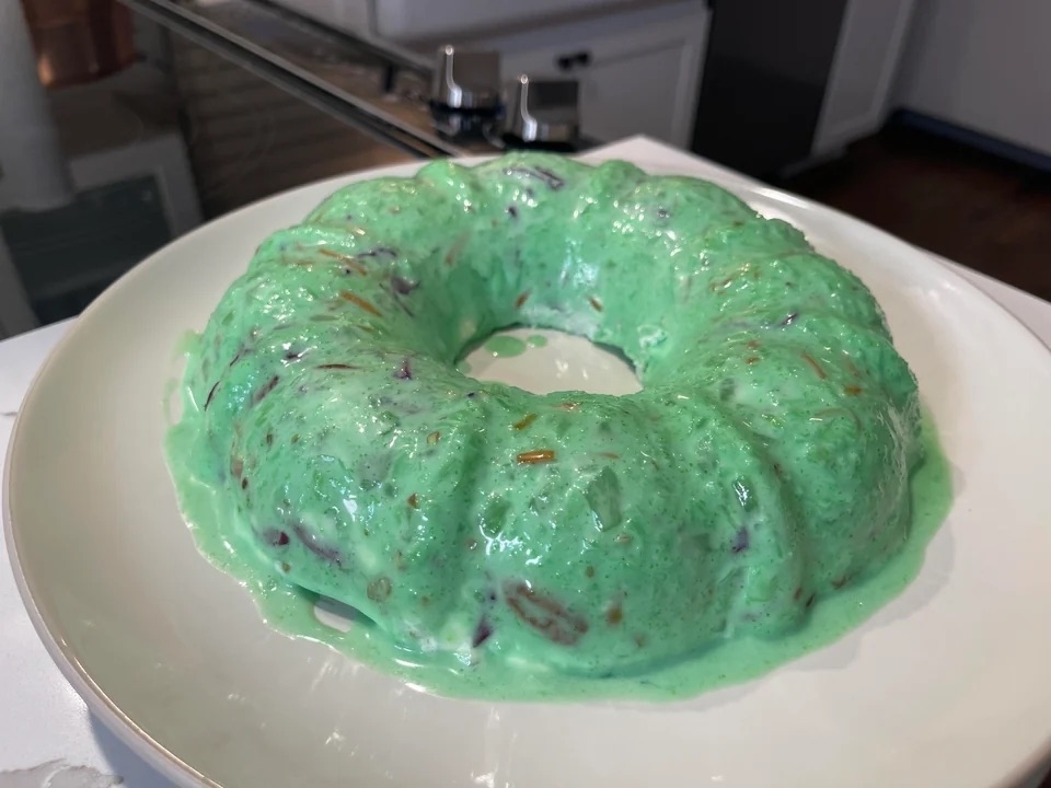a bright green jello salad in the shape of a ring
