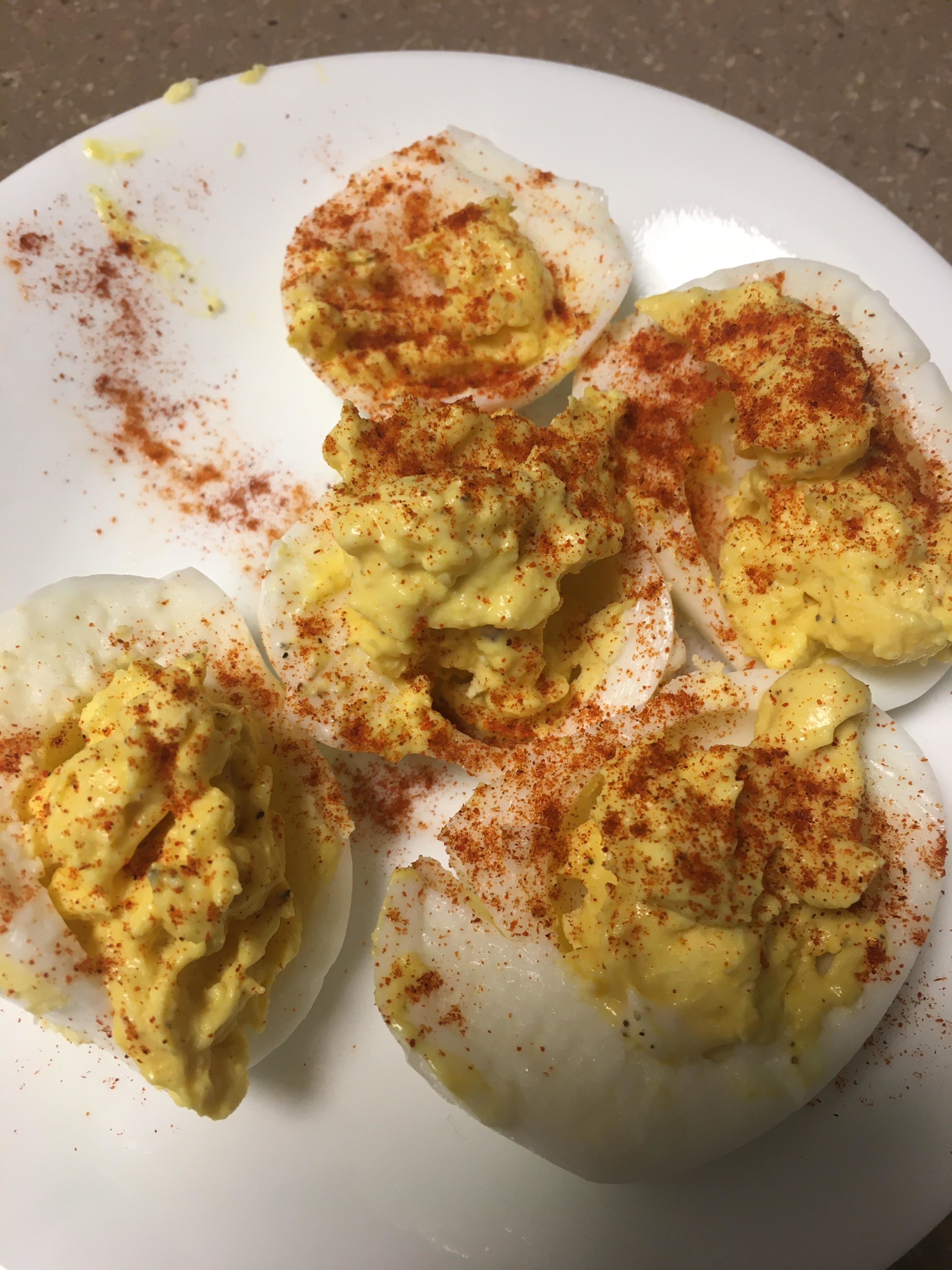 messy deviled eggs sprinkled with paprika
