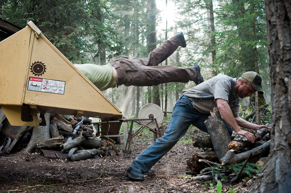 Alan Tudyk bending over while Joseph Allan Sutherland dives into a wood chipper.