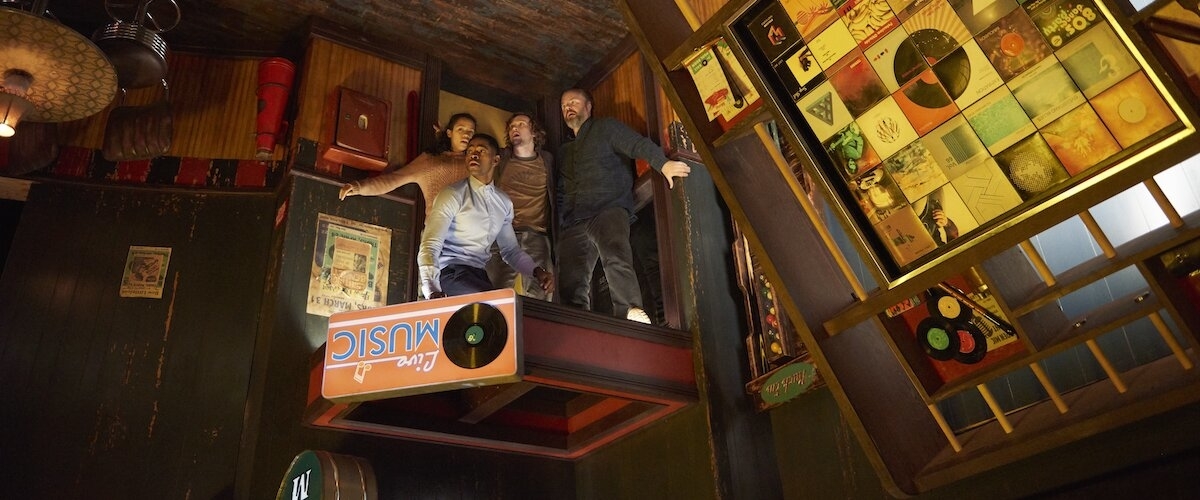 Taylor Russell, Logan Miller, Jay Ellis, and Tyler Labine entering an escape room shaped like an upside-down billiards bar.