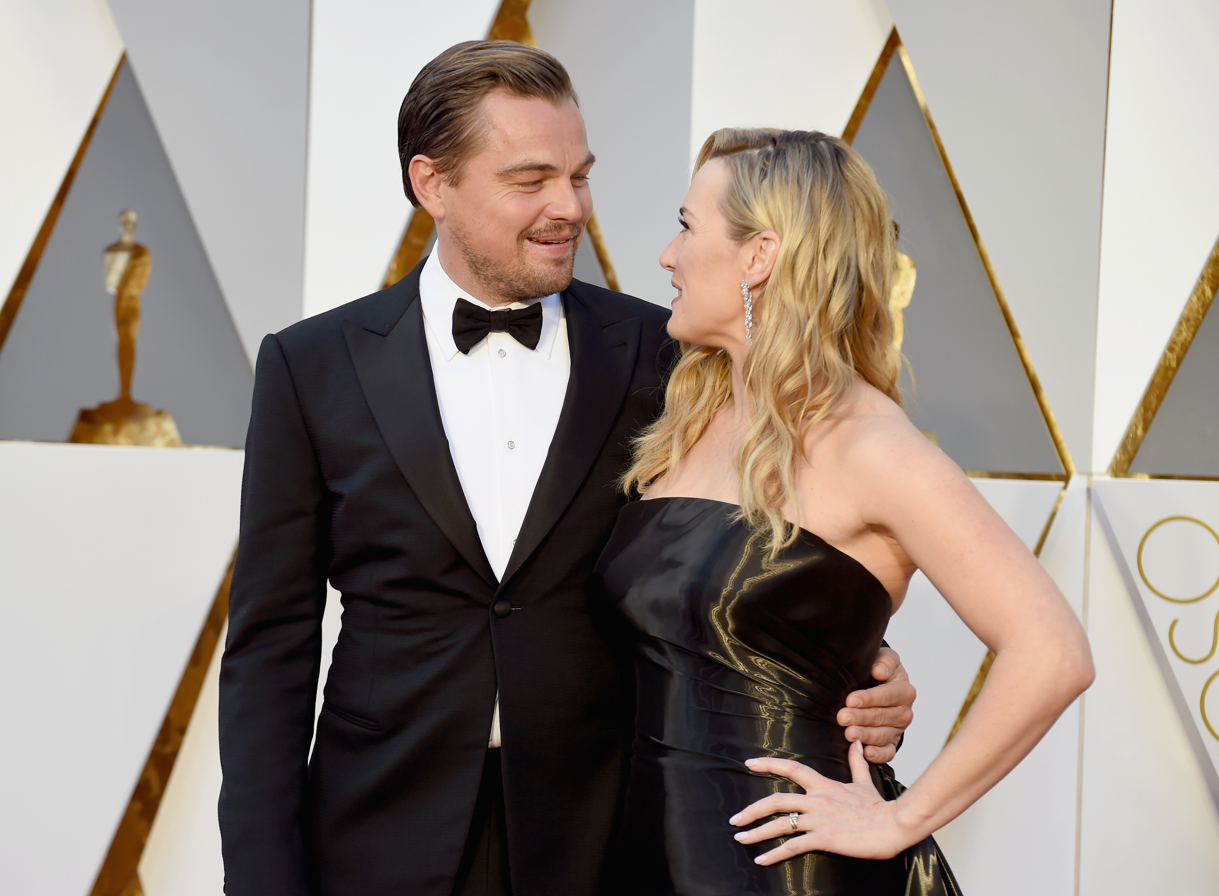 Leo and Kate smiling at each other at the Oscars