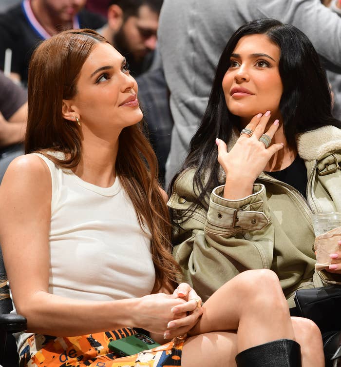 Kendall and Kylie sitting next to each other at a sports event