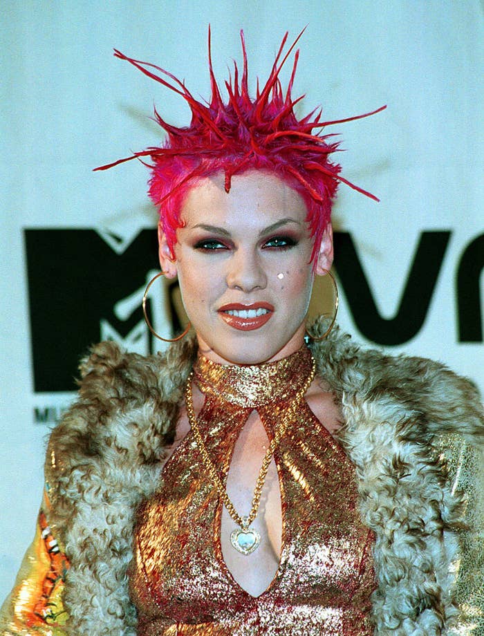 Closeup of Pink with spiked pink hair, a shiny halter top and a furry coat