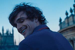 Jacob Elordi smiling and looking back as Felix in Saltburn