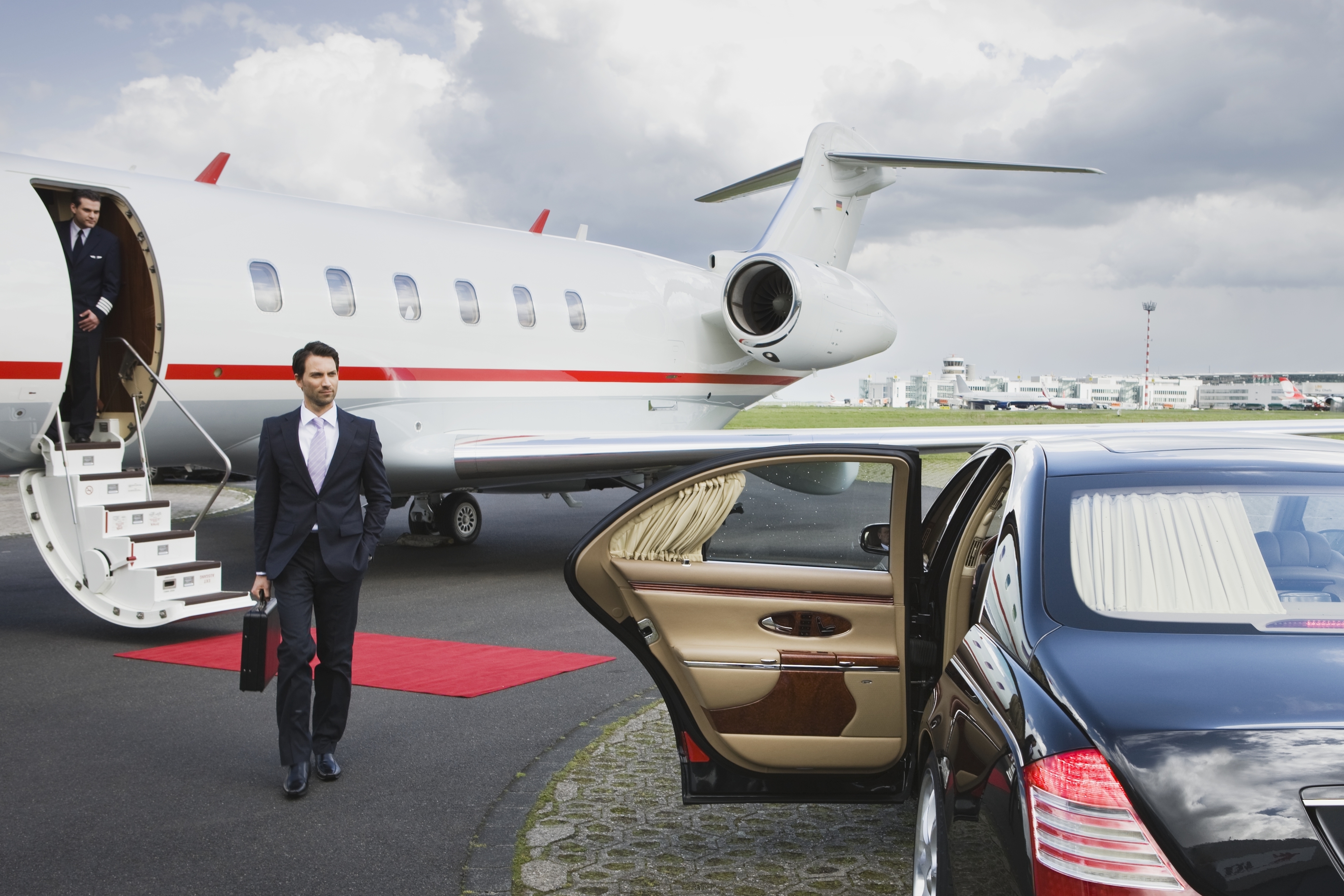 A man walking from a private jet to a car that&#x27;s waiting for him with the door open