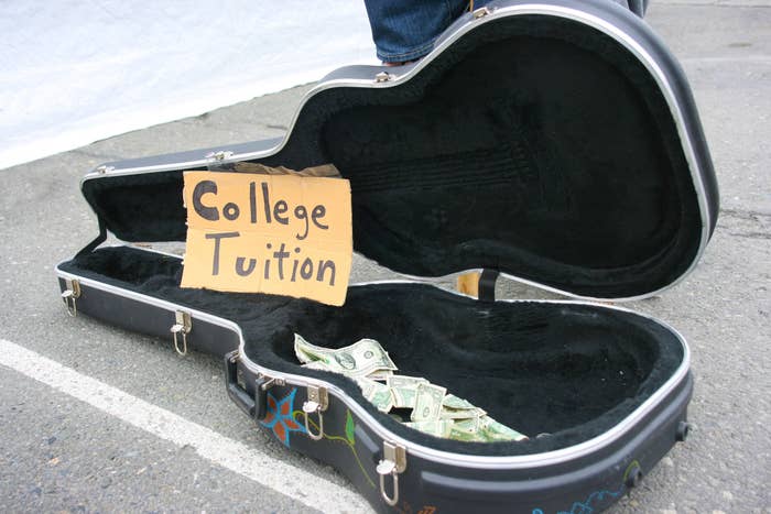 An empty guitar case with money in it and a sign saying &quot;College tuition&quot;