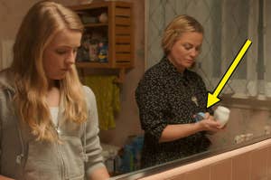 Amy Poehler putting on cream in the mirror