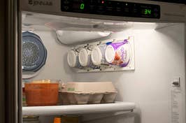 open fridge with vertical yogurt cup holder on wall