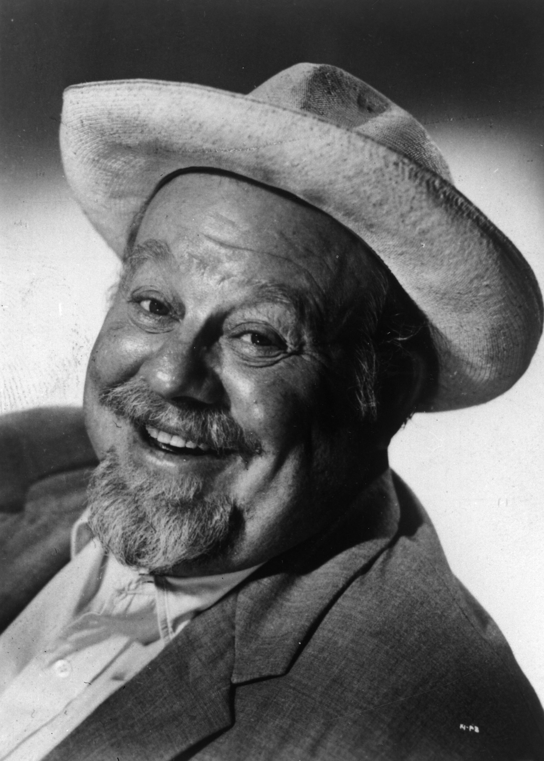 Close-up of a smiling older man wearing a Western-style hat