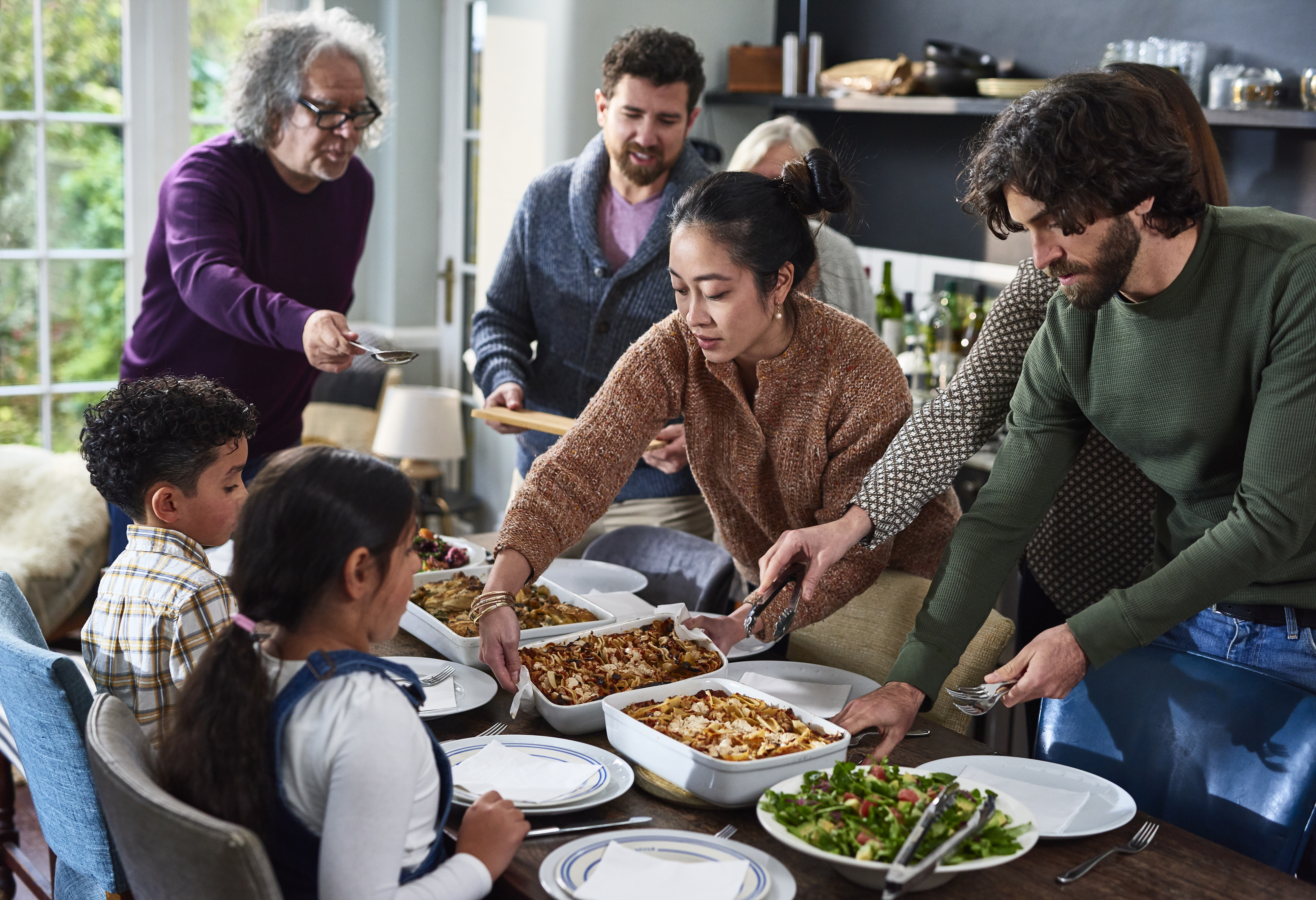 adults and children around a table with food