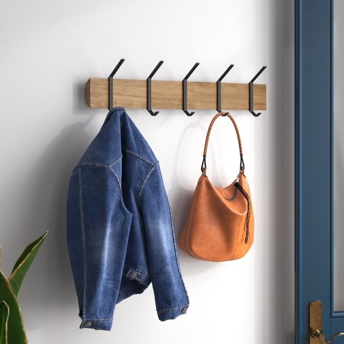 the black wall hooks with a jacket and bag hanging from them