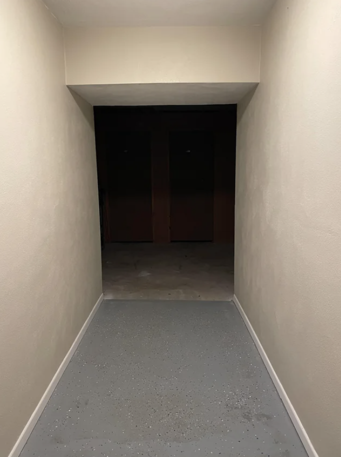 A hallway leading to a dark opening