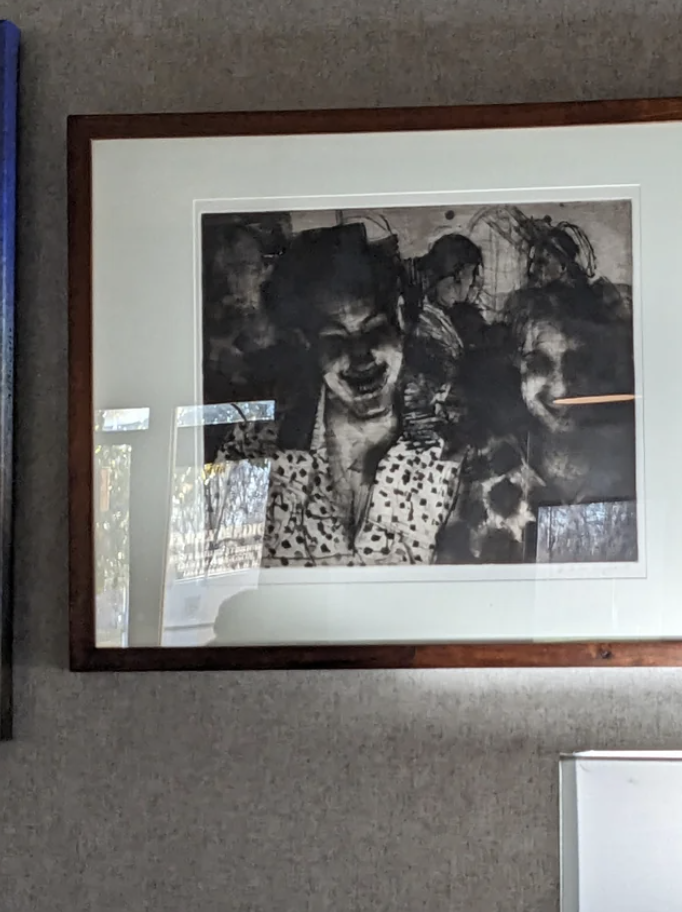A framed photo of distorted, shadowy smiling faces