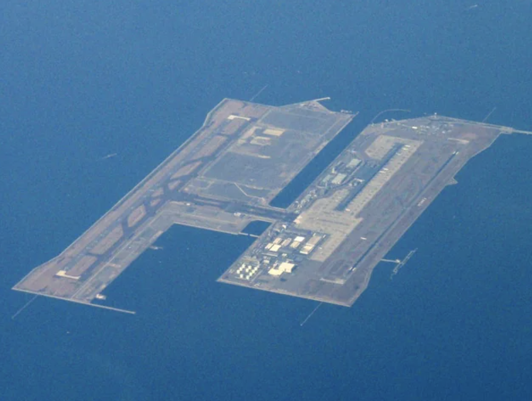 An airport and runway surrounded by blue water, as seen from the air