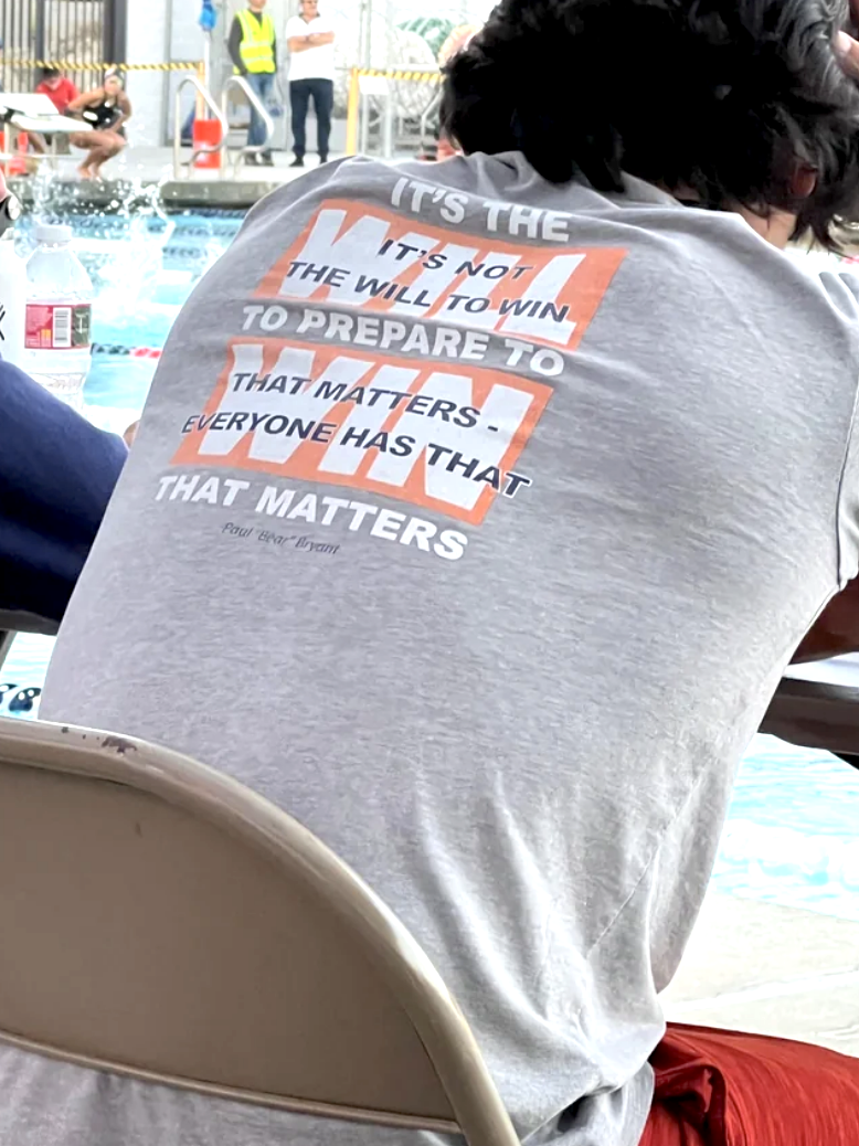 "It's the will to prepare to win that matters" written on the back of someone's T-shirt