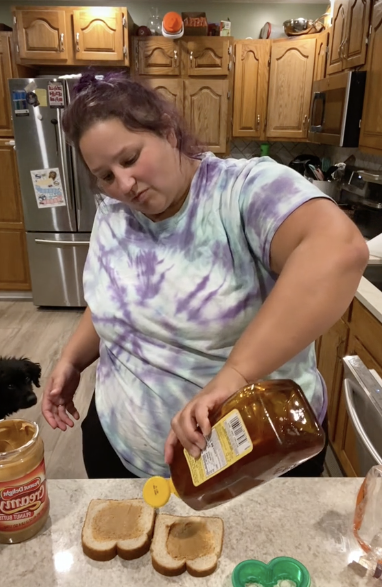 jessica squeezing honey on a slice of bread with peanut butter