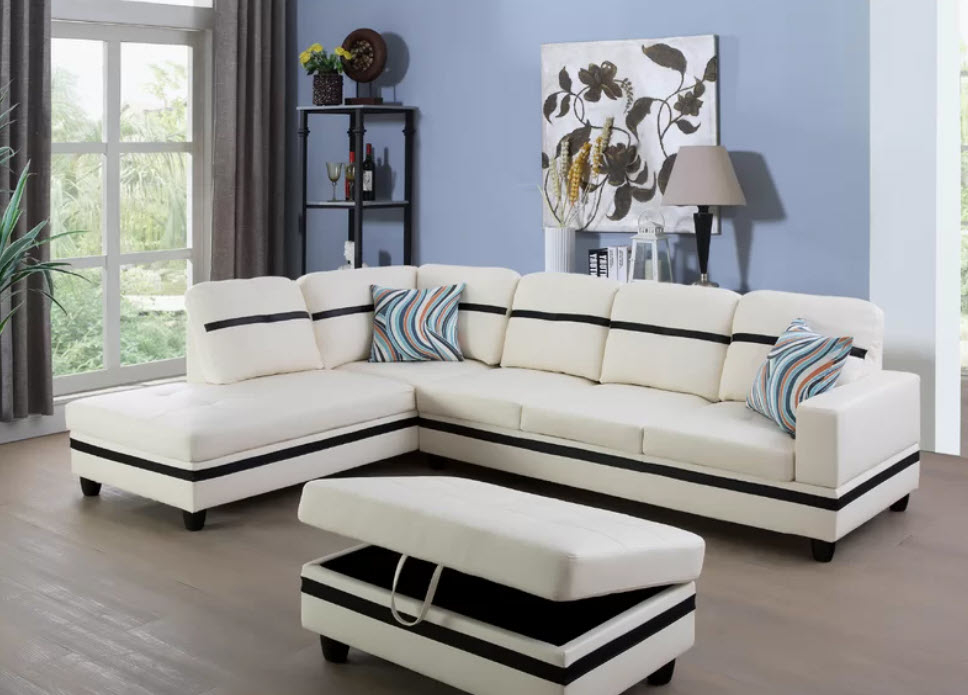 large white sectional couch with black strip design and matching storage ottoman