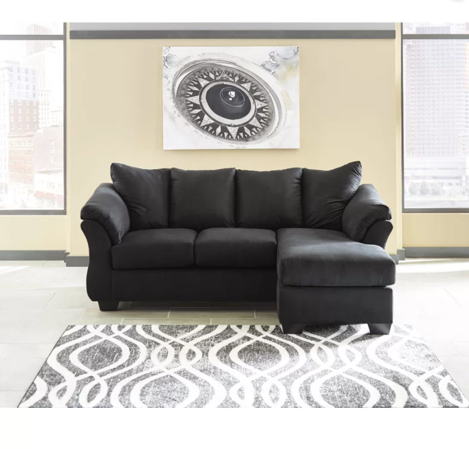 black L-shaped sofa with cushions