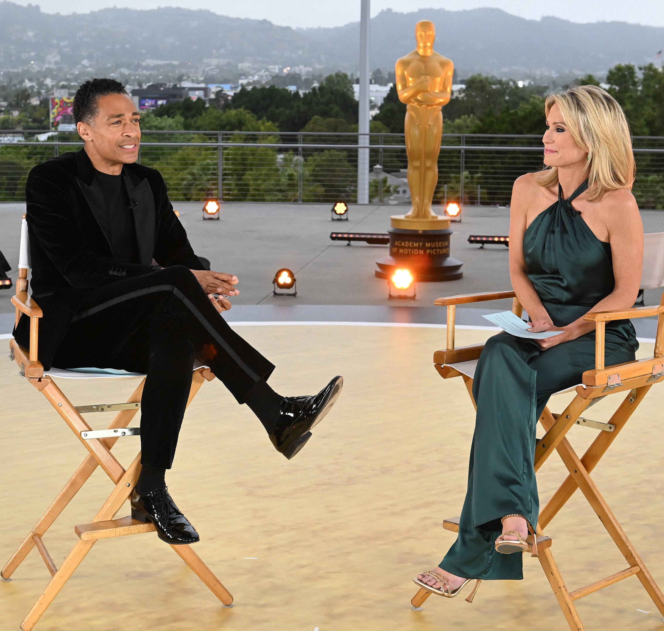 the two sitting in director&#x27;s chairs outside