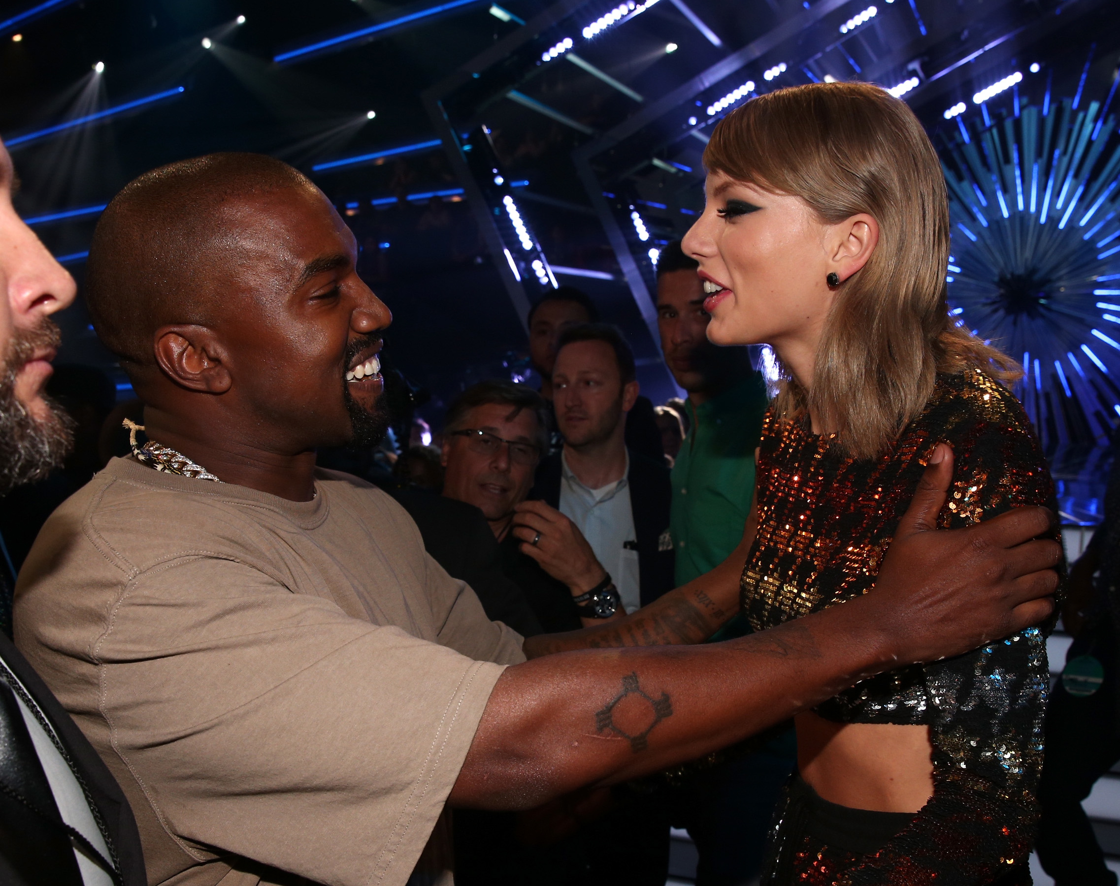 kanye grabbing taylor&#x27;s shoulders as the two talk at a show