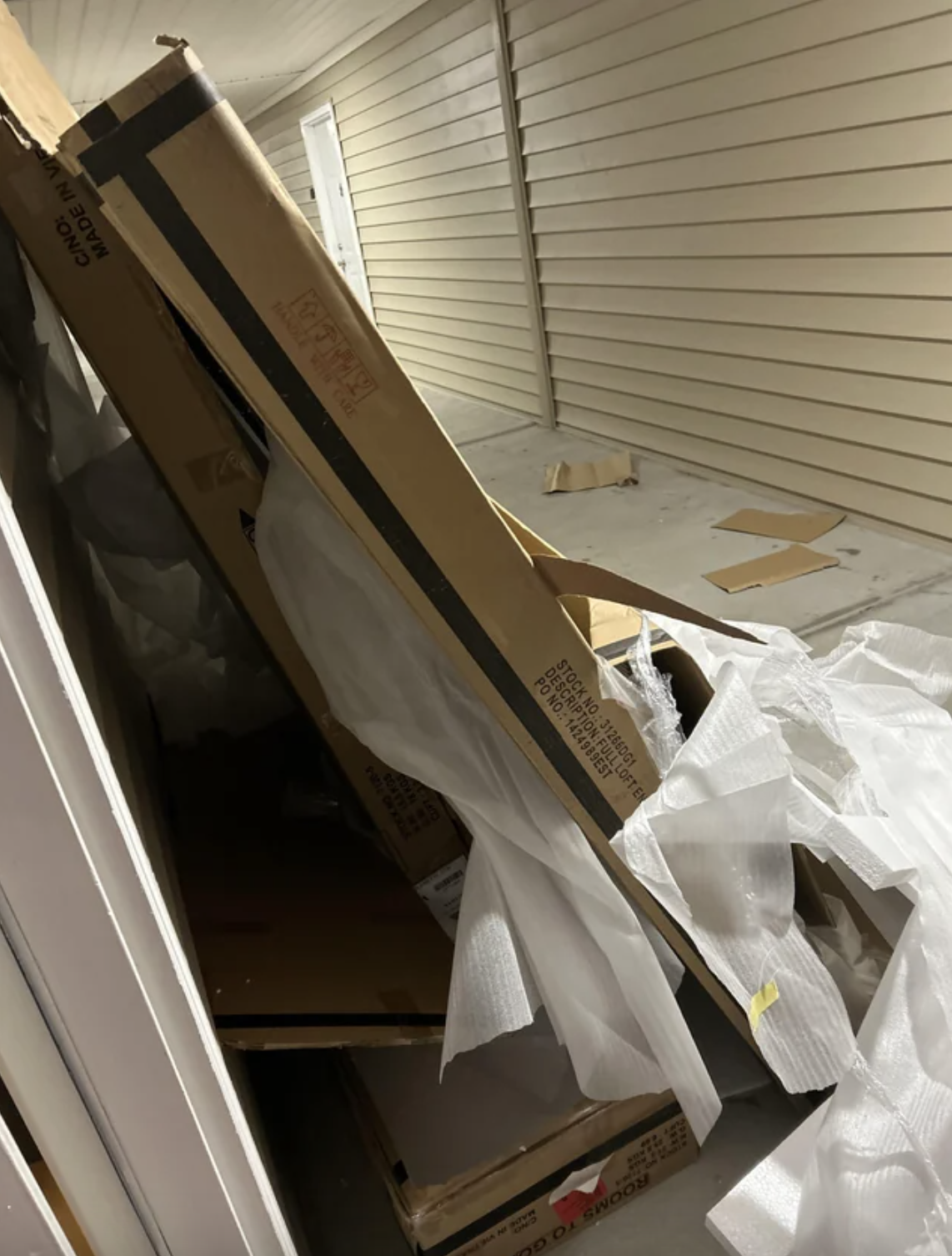 tall opened boxes and trash in the hallway