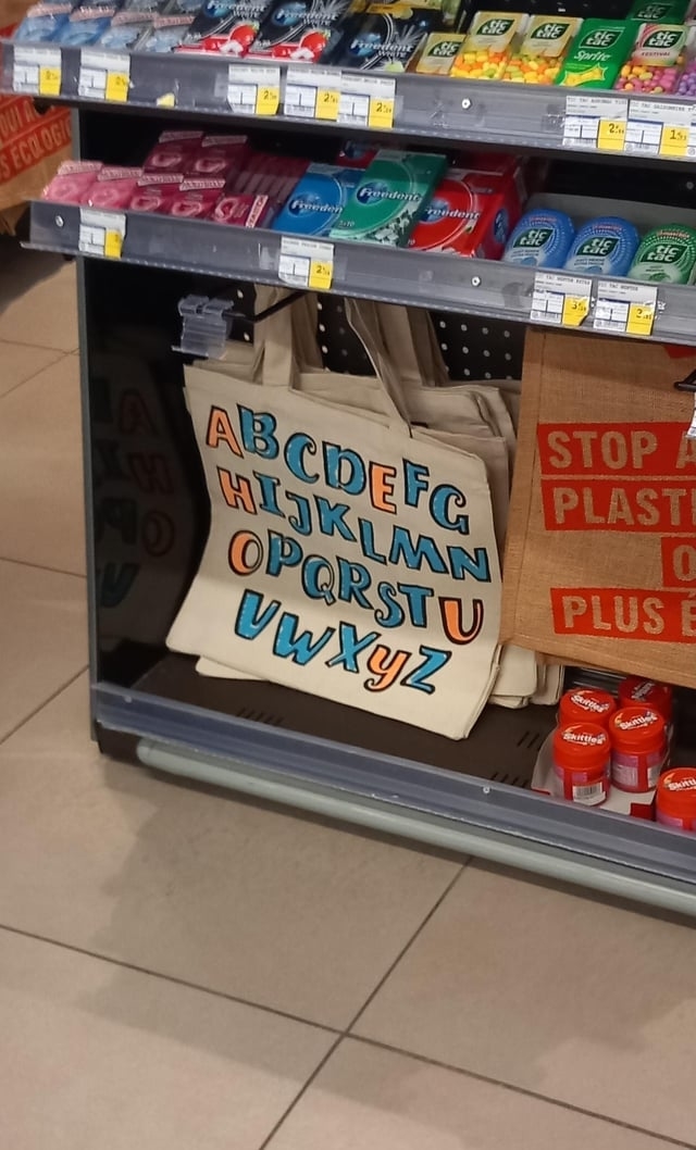 A sign with the alphabet and the wrong vowels pointed out in a separate color