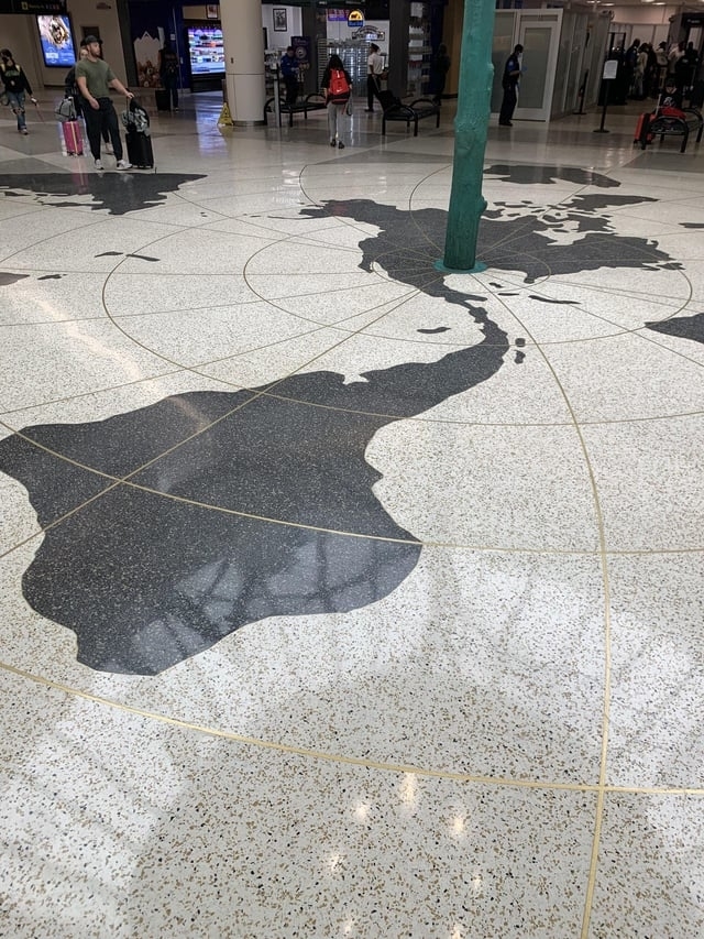 A map on the floor of a building, with South America upside down